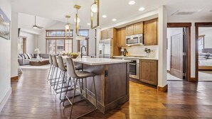 Une cuisine spacieuse dotée d’un îlot central, de meubles en bois et d’appareils électroménagers modernes.