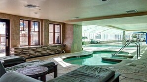 Un espace spa comprenant une piscine, des chaises longues et un coin salon avec vue sur la piscine.