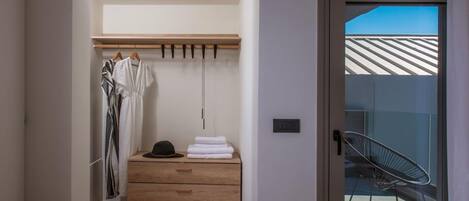 A modern bathroom with a wooden vanity, a hanging towel rack, and a pair of shoes on the floor.