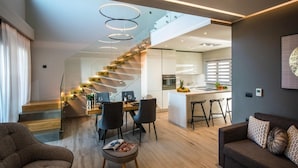 Un salon moderne avec un escalier menant à la cuisine et à la salle à manger.