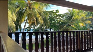 A balcony with a view of palm trees and a beach. - Villa Carla - Grandiose stays by the sea (Antsiranana)