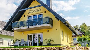 A yellow building with a balcony and a sign that reads "SeenSucht."