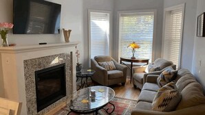 Un salon avec une cheminée, un téléviseur, un canapé et une table basse.