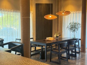 A modern dining area with a dark wooden table, black chairs, and two woven pendant lights. - Blossom Hill Hotel Wuxi Yangshan (Wuxi)