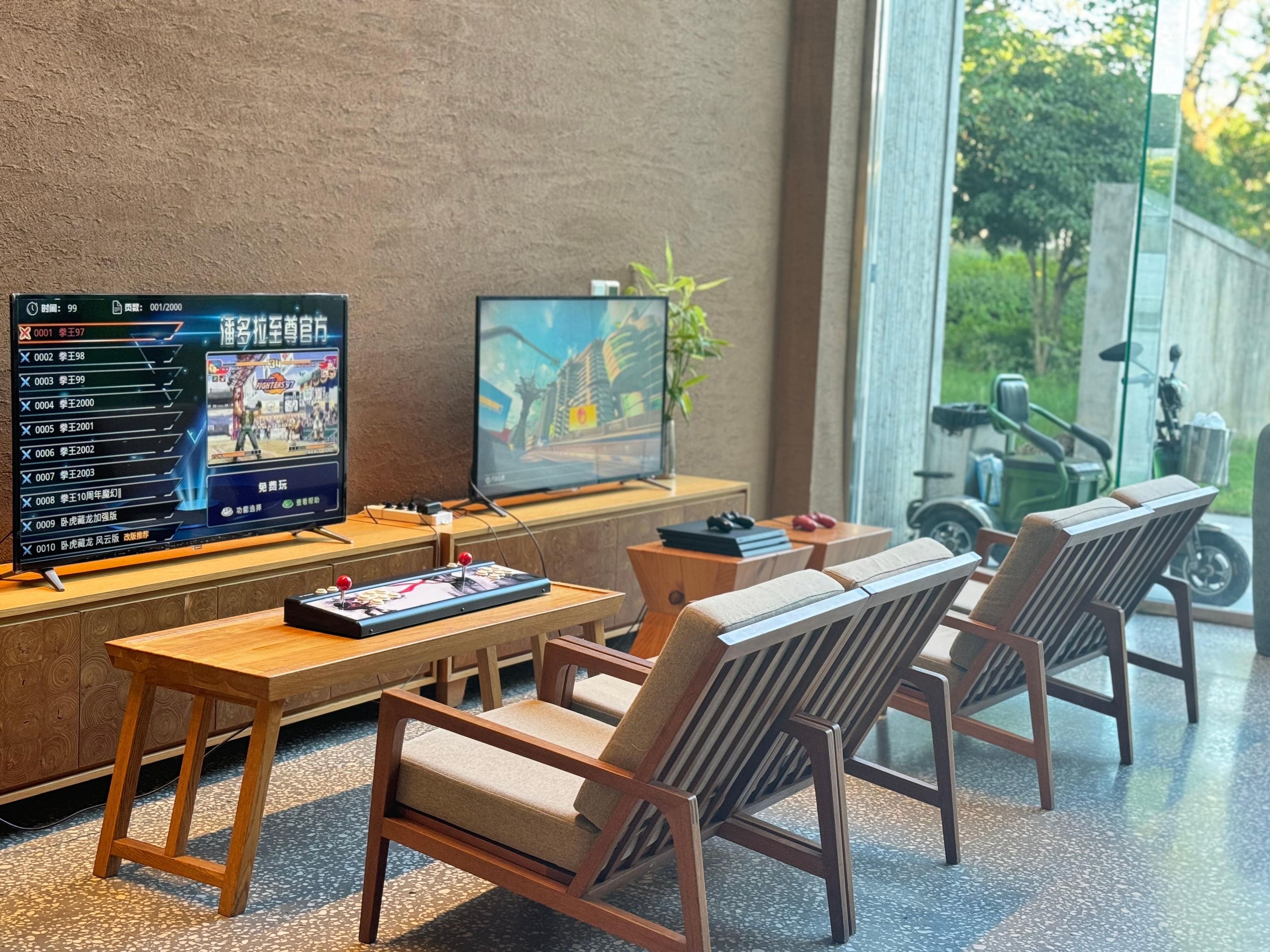 Een moderne woonkamer met een grote flatscreentelevisie, houten meubels en uitzicht op de natuur.
