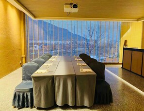 A conference room with a long table, chairs, and a projector. - Blossom Hill Hotel Wuxi Yangshan (Wuxi)