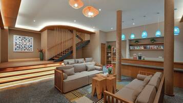 A modern interior with a sofa, a staircase, and a bookshelf.