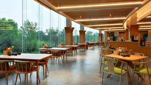 A spacious dining area with high ceilings, large windows, and a view of the outdoors. Tables and chairs are arranged neatly, and the floor is made of polished stone. - Blossom Hill Hotel Wuxi Yangshan (Wuxi)