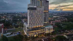 Un hôtel de grande hauteur, reconnaissable à son grand panneau « Courtyard by Marriott », avec de nombreux étages et une architecture moderne.