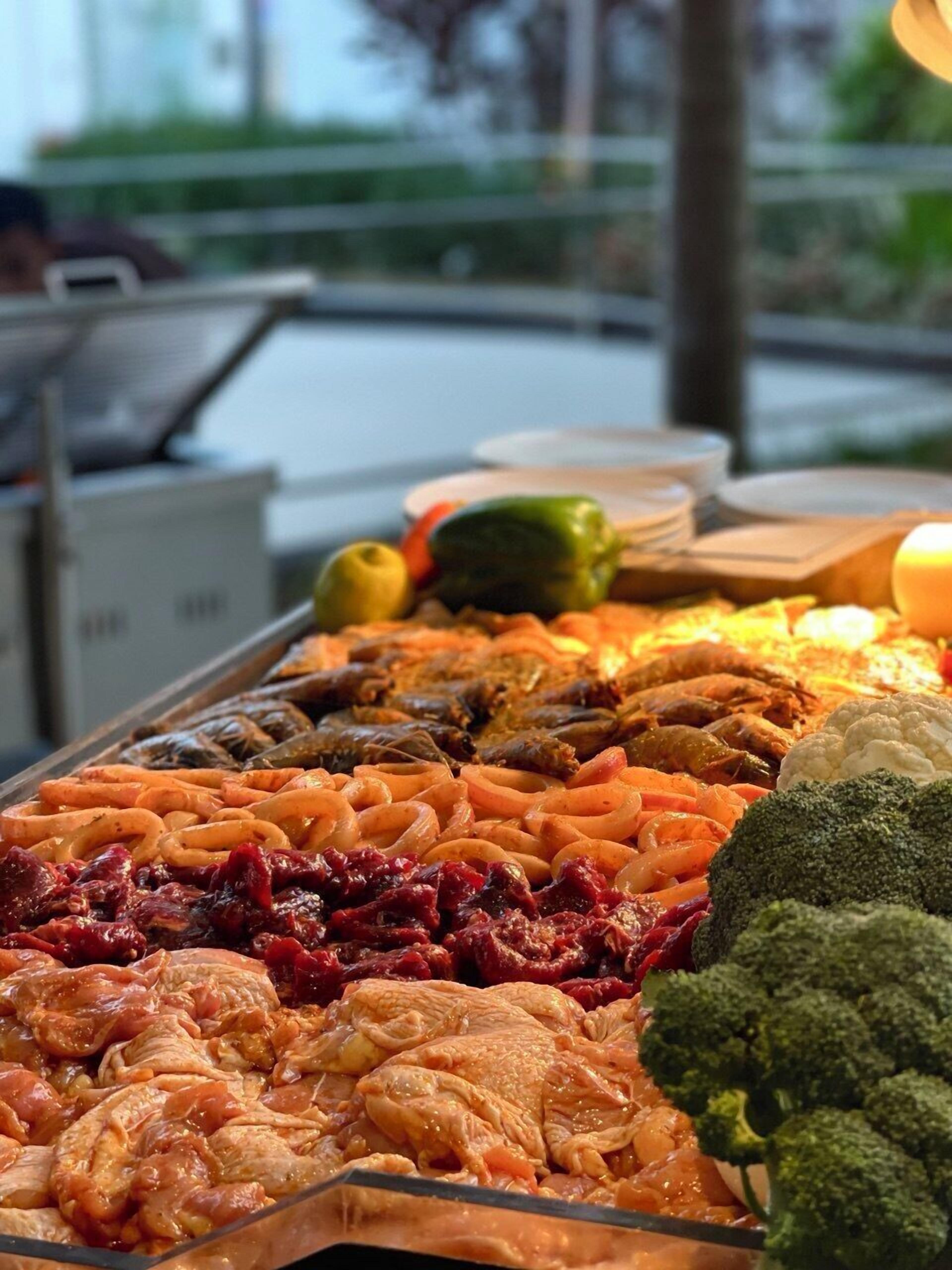A buffet with various dishes including meats, vegetables, and seafood.