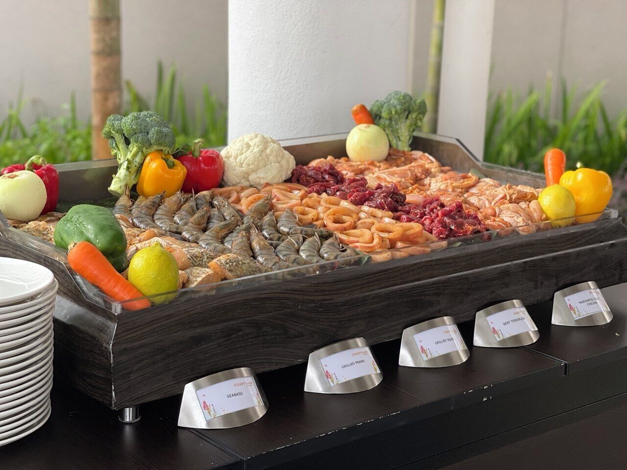 A buffet with various food items and labeled serving dishes.