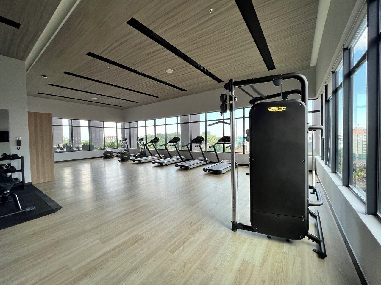 A modern gym with treadmills, a squat rack, and weightlifting equipment.