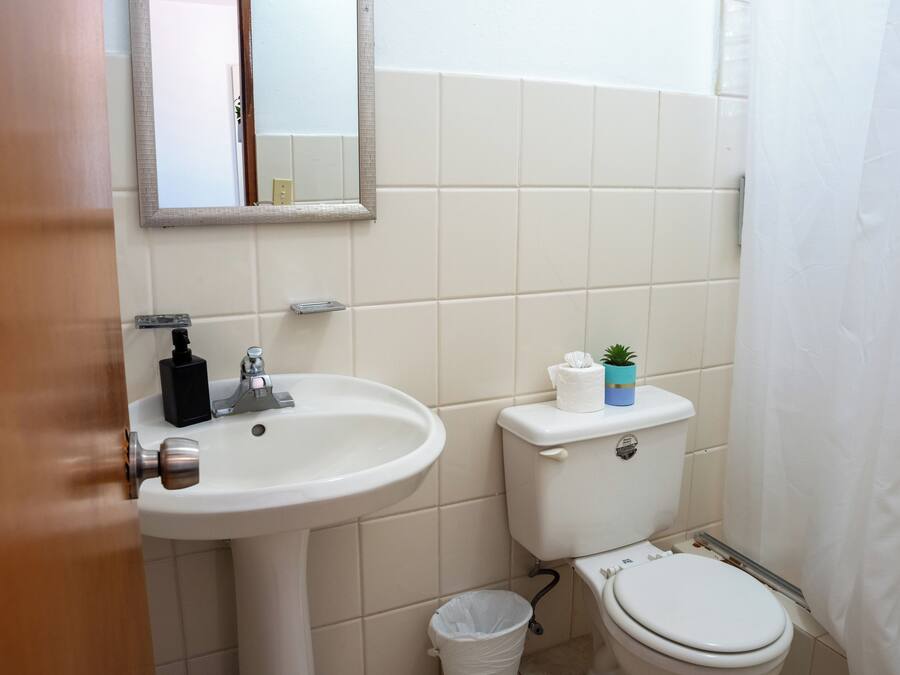 Ein Badezimmer mit Waschbecken, Toilette und einem kleinen Mülleimer.