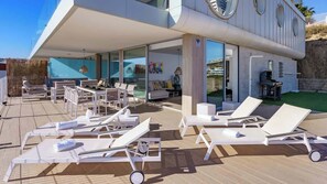A modern outdoor lounge area with sun loungers and a covered seating area. - Lux Apt Med One by Costarentals - Ref 191 (Fuengirola)