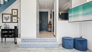Ein modernes Interieur mit einer Treppe, die zu einem Essbereich führt, einem schwarzen Schrank mit Gläsern und einem großen Flachbildfernseher.