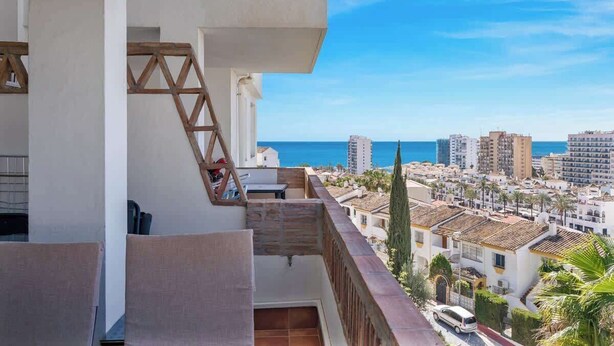 Ein Balkon mit Blick auf das Meer und die umliegenden Gebäude.