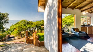 Un interior moderno con vistas a un jardín exuberante y montañas.