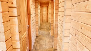 A wooden hallway with a door on the left and a staircase leading to an upper level. - Ilodge Ultra (Louth)