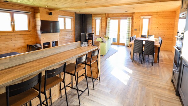 A spacious kitchen with wooden walls and a large dining area. - Ilodge Ultra (Louth)