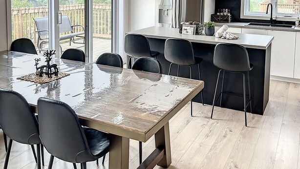 A modern kitchen with a large island, pendant lights, and a view of the outdoors. - The Double Diamant (St-Côme)