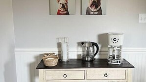 Eine Küchenarbeitsplatte mit Kaffeemaschine, Wasserkocher und einer Korb.