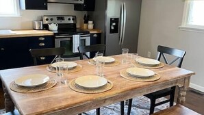 Ein Essbereich mit einem Holztisch, gedeckt für sechs Personen, einer Bank und einer Hängeleuchte.