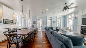 Una cocina amplia con una larga mesa de madera, sillas de madera oscura y un sofá seccional azul.