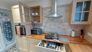 A compact kitchen with a microwave, toaster, and a pot on the counter. - Ravensdale Villa- Ideal For Longer Stays in Kent (Gillingham)
