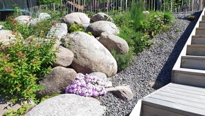 A garden with large rocks, gravel paths, and various plants. - Lakeview Loft, Private Retreat at Lake Skagern (Finnerödja)