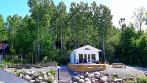 A cabin with a deck, surrounded by a forest. - Tree of Life Lakeview Loft Retreat (Finnerödja)