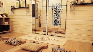 A room with a wooden floor, a patterned rug, and several cushions with owl designs. - Tree of Life Lakeview Loft Retreat (Finnerödja)