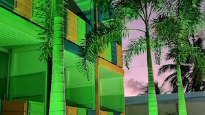 Un edificio con fachada iluminada en verde y varias puertas de garaje.