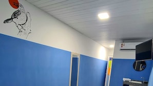 Habitación de hotel con dos camas, un baño pequeño y un mural en la pared.