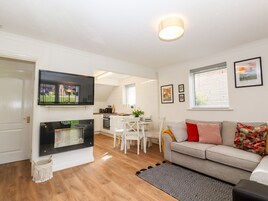 A modern living room with a fireplace, a television, a dining area, and a sofa.