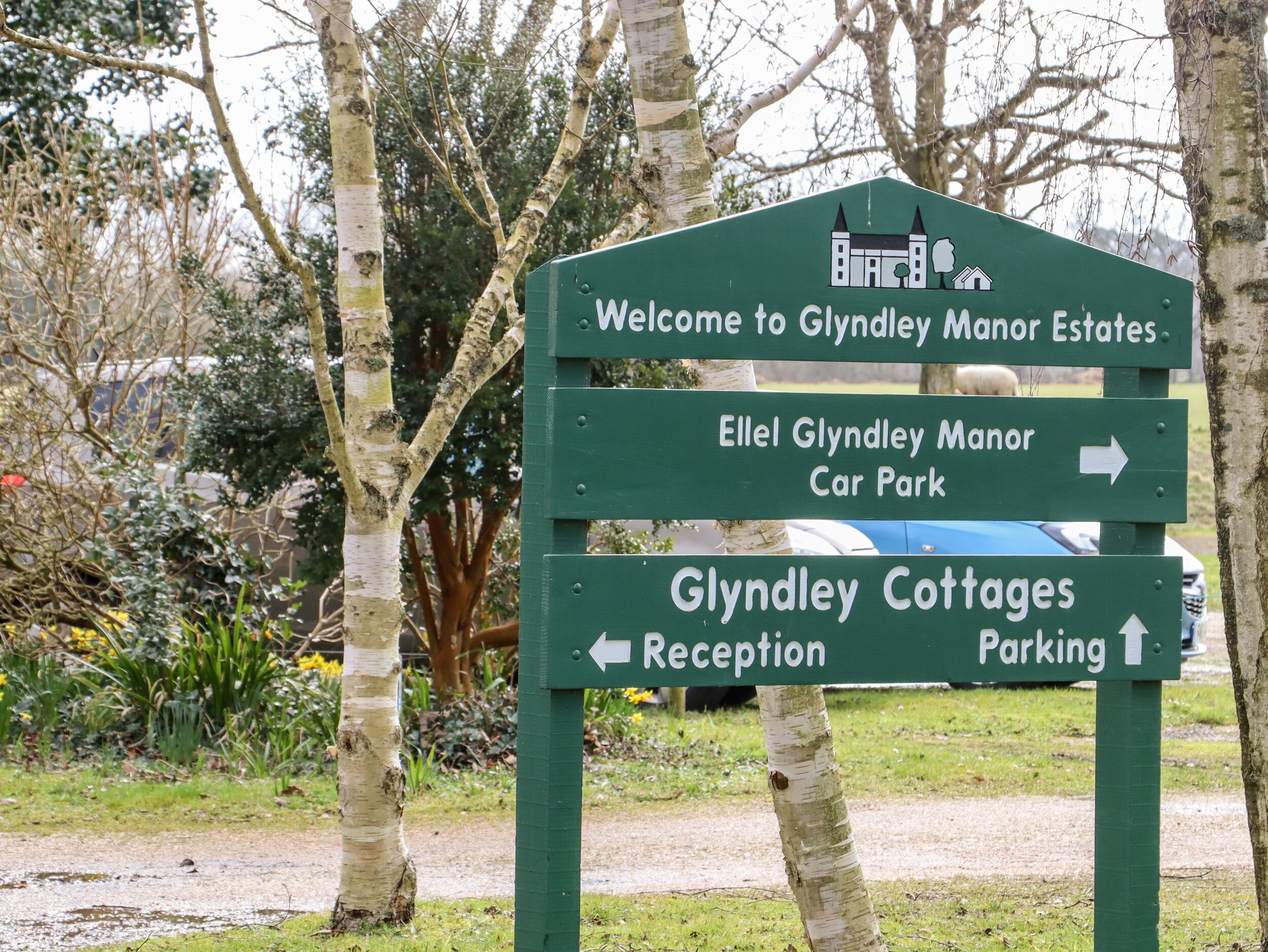 A directional sign at Glyndley Manor Estates with arrows pointing to Glyndley Cottages Reception and Car Park.