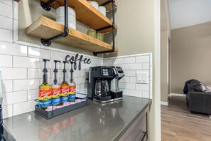 A kitchen with a coffee station, including a coffee maker and Torani syrup bottles. - 1\2 Mile Dwntwn Gilbert Beauty-Priv Pool+Free Heat (Gilbert)