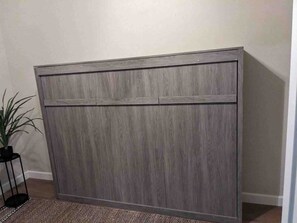 A large, grey, wooden cabinet with a flat top and two doors.
