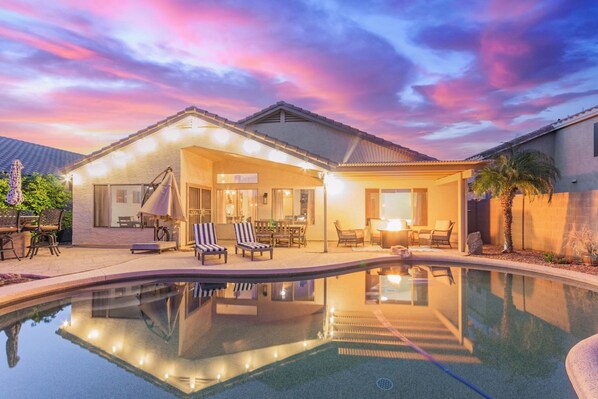 Um imóvel residencial com piscina, área de estar externa e um espaço de varanda coberto.