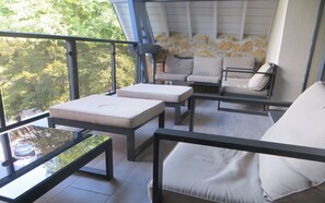 Relax in a stylish outdoor seating area with a glass table, cushioned bench, and sofa.