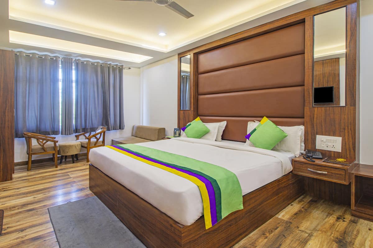 Una habitación de hotel con una cama grande, un escritorio y una silla.