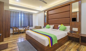 A hotel room with a large bed, a desk, and a chair. - Treebo The Empire Near Taj Mahal Agra (Agra)