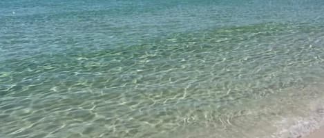 A beach with clear turquoise water and a sandy shore.