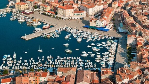 An aerial view of a coastal town with a dense cluster of buildings, a prominent tower, and a marina filled with boats. - Room in Rovinj with Seaview, Balcony, Air condition, WIFI (81-1) (Rovinj)