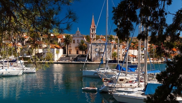 A marina with boats docked, a prominent church with a bell tower, and buildings with red-tiled roofs. - Holiday Home in Milna with Terrace, Air condition, WIFI, Washing machine (5123-1) (Milna)