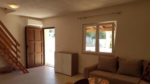 A living room with a sofa, a coffee table, and a dining area with chairs. There is a sliding door leading to an outdoor area. - Holiday Home in Milna with Terrace, Air condition, WIFI, Washing machine (5123-1) (Milna)