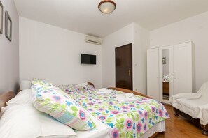 A bedroom with a bed, a wardrobe, and a television on the wall. - Apartment in Omiš with Seaview, Loggia, Air condition, WIFI (5129-4) (Omiš)