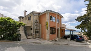 Un edificio de dos pisos con fachada de piedra y un balcón.
