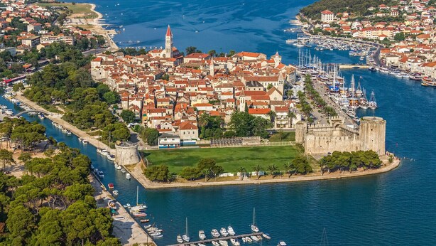 An aerial view of a coastal town with a prominent castle, a marina with numerous boats, and a dense cluster of buildings with red-tiled roofs. - Apartment in Slatine with Seaview, Terrace, Air condition, WIFI (5130-2) (Slatine)