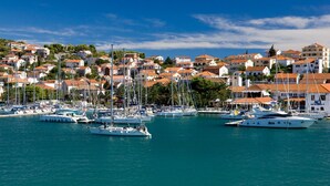 A marina with multiple sailboats docked, surrounded by residential buildings with red-tiled roofs. - Apartment in Slatine with Seaview, Terrace, Air condition, WIFI (5130-2) (Slatine)