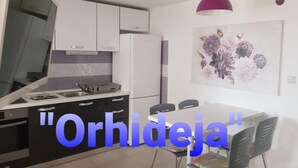 A modern kitchen with white cabinets, a black countertop, and a dining area with a table and chairs. - Apartment in Slatine with Seaview, Terrace, Air condition, WIFI (5130-2) (Slatine)